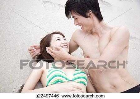 Japanese couple lying on a beach in swimsuit View Large Photo Image Stock Photograph - Japanese couple lying on a beach in swimsuit. Fotosearch