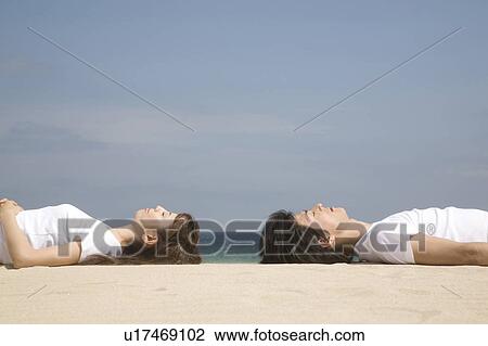 Japanese couple lying on a beach View Large Photo Image Stock Image - Japanese couple lying on a beach. Fotosearch
