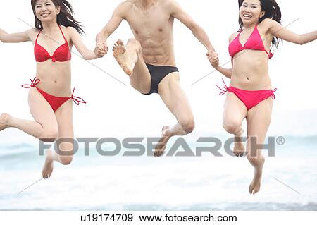 Stock Photo - Japanese in swimsuit playing in a beach. Fotosearch
