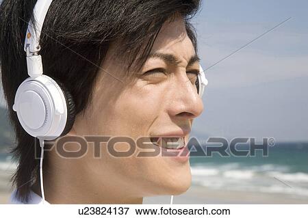 Stock Photo - Japanese man listening to music. Fotosearch