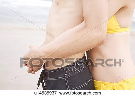 Stock Photo - Japanese woman embraces lover from back. Fotosearch