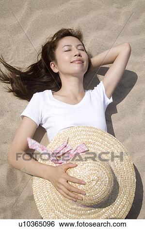 Japanese woman lying on a beach View Large Photo Image Stock Photograph - Japanese woman lying on a beach. Fotosearch