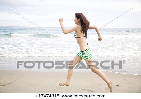 Japanese woman walking on a beach in swimsuit View Large Photo Image Stock Photography - Japanese woman walking on a beach in swimsuit. Fotosearch