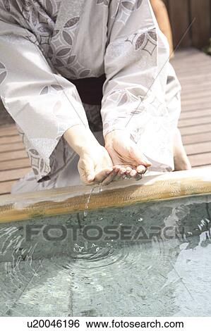 Stock Photograph - Hand of Japanese woman scooping the hot water of the hot spring. Fotosearch