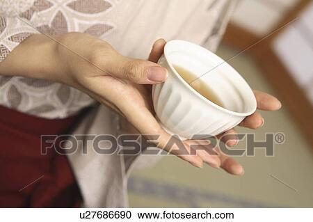Stock Image - Hand of woman having a teacup. Fotosearch