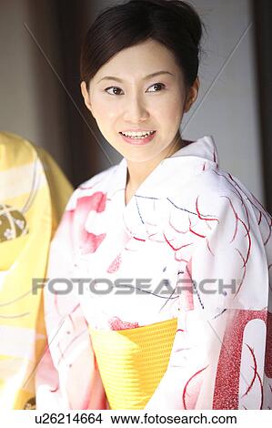 Picture - Japanese woman putting on a yukata. Fotosearch