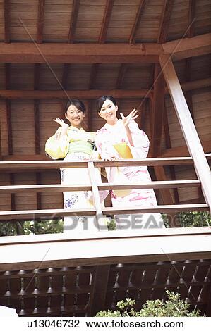 Stock Image - Japanese woman putting on a yukata. Fotosearch