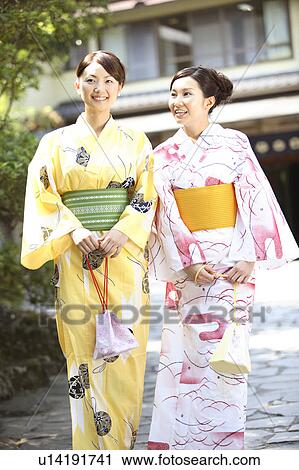 Stock Image - Japanese woman putting on a yukata. Fotosearch