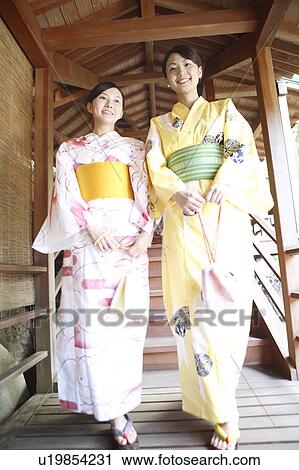 Stock Image - Japanese woman putting on a yukata. Fotosearch