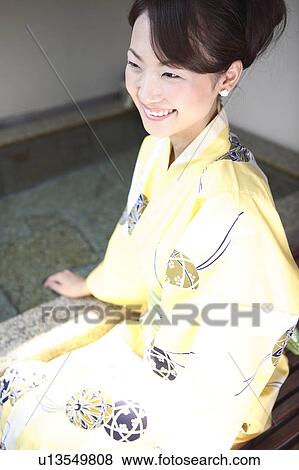 Stock Photo - Japanese woman putting on a yukata. Fotosearch