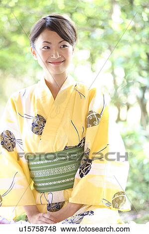 Stock Photo - Japanese woman putting on a yukata. Fotosearch