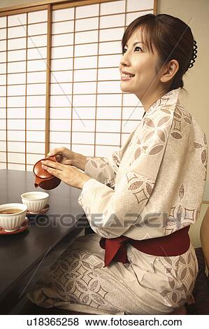 Japanese woman putting on kimono View Large Photo Image Stock Photo - Japanese woman putting on kimono. Fotosearch