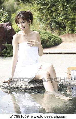 Stock Photo - Japanese woman soaking the open-air bath. Fotosearch