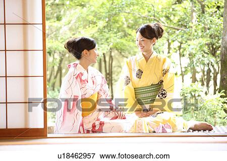 Stock Photo - Japanese women sitting on the wooden passageway. Fotosearch