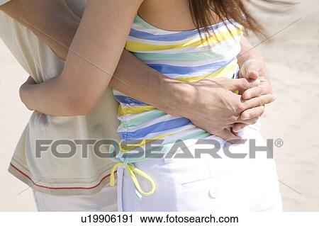 Couple hugging each other on a beach View Large Photo Image Stock Image - Couple hugging each other on a beach. Fotosearch