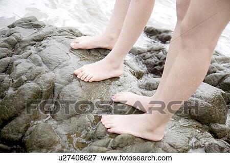 Foot of a couple standing in the rocky place View Large Photo Image Stock Photo - Foot of a couple standing in the rocky place. Fotosearch