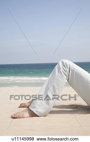 Stock Photo - Foot of man lying on a beach. Fotosearch