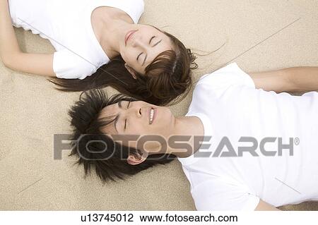 Japanese couple lying on a beach View Large Photo Image Stock Image - Japanese couple lying on a beach. Fotosearch