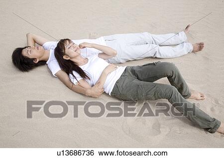 Japanese couple lying on a beach View Large Photo Image Stock Photograph - Japanese couple lying on a beach. Fotosearch