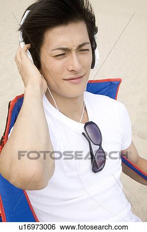 Stock Photograph - Japanese man listening to music. Fotosearch