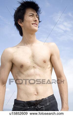 Stock Photo - Portrait of Japanese man in swimsuit. Fotosearch