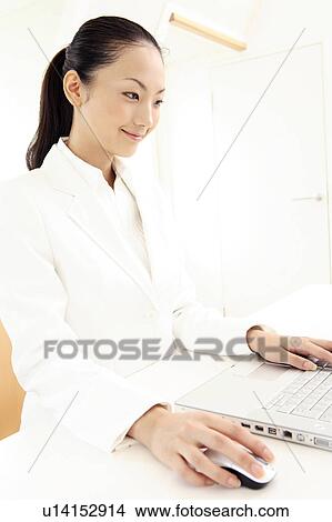 Picture - Office lady operating a PC. Fotosearch
