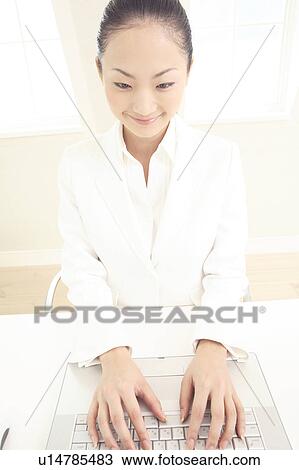 Stock Image - Office lady operating a PC. Fotosearch