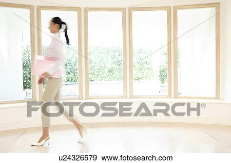 Stock Photo - Office lady walking in a room. Fotosearch