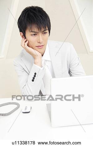 Stock Photo - Office worker gazing a PC monitor. Fotosearch