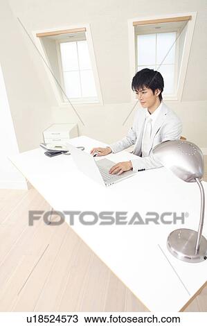 Stock Image - Office worker operating a laptop PC. Fotosearch