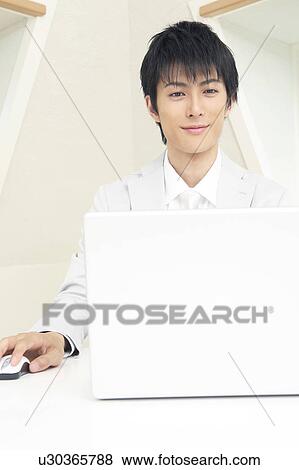 Office worker operating a laptop PC View Large Photo Image Stock Photo - Office worker operating a laptop PC. Fotosearch