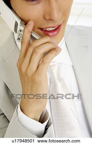 Stock Image - Office worker talking with cell phone. Fotosearch