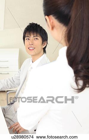 Picture - Office worker talking with fellow. Fotosearch