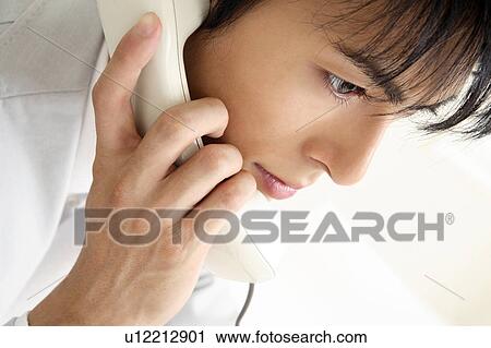 Stock Image - Office worker talking with phone. Fotosearch