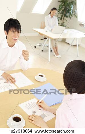 Picture - Office workers having a brief meeting. Fotosearch