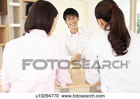 Office workers having a brief meeting View Large Photo Image Stock Image - Office workers having a brief meeting. Fotosearch