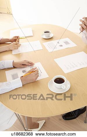 Stock Photo - Office workers having a brief meeting. Fotosearch
