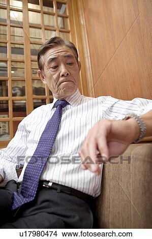 Picture - Japanese CEO relaxed on the sofa. Fotosearch