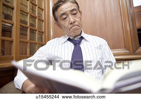 Picture - Japanese executive reading a book. Fotosearch