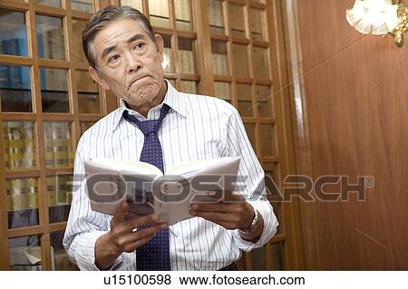 Japanese executive reading a book View Large Photo Image Stock Photo - Japanese executive reading a book. Fotosearch