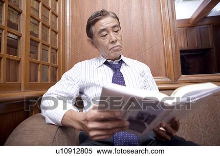 Stock Photography - Japanese executive reading a book. Fotosearch
