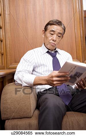 Stock Photography - Japanese executive reading a book. Fotosearch