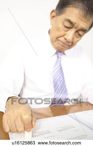 Stock Image - Chief executive officer pushing the stamp. Fotosearch