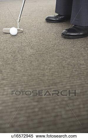 Stock Photography - Foot of Japanese chief executive officer practicing golf. Fotosearch