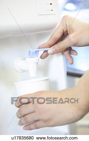Stock Image - Hand of a woman serving water. Fotosearch