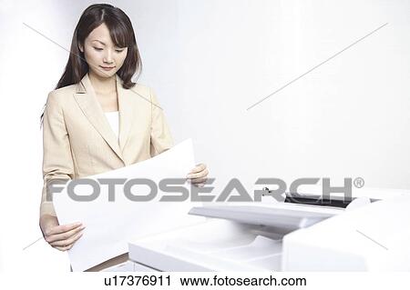 Stock Image - Japanese office lady taking a copy. Fotosearch