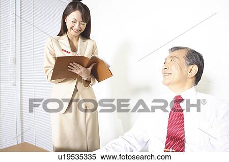 Stock Photography - Japanese office lady taking a memo. Fotosearch