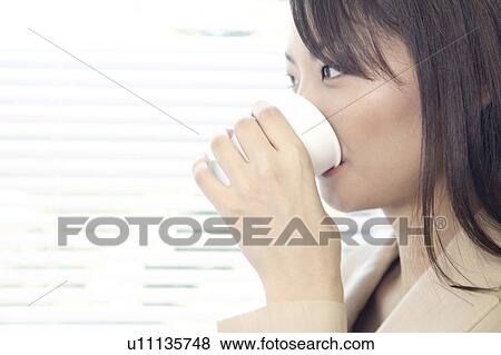 Stock Photo - Office lady drinking a water. Fotosearch