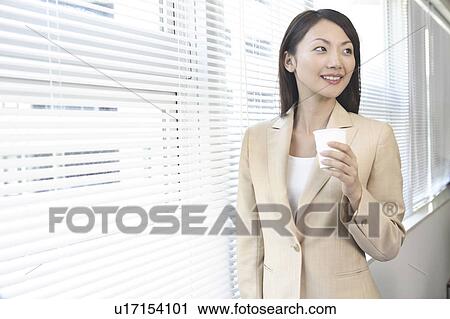 Stock Image - Office lady having a paper cup. Fotosearch