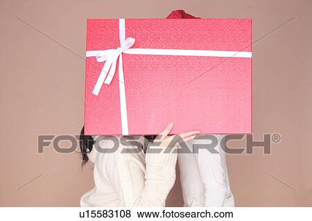 Couple hidden by gift box View Large Photo Image Stock Photo - Couple hidden by gift box. Fotosearch